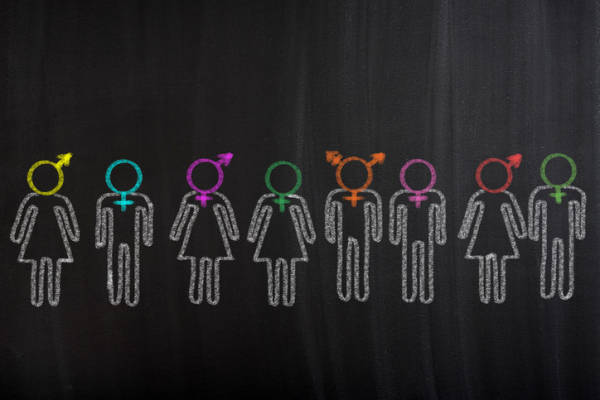illustration resembling a chalk drawing of a line of figures on a black background with a variety of gender identity symbols in different colors for heads